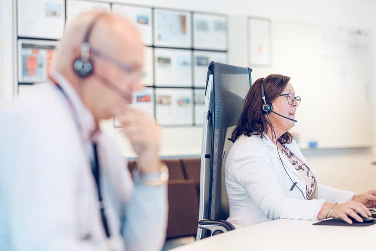 Crisis management professionals actively monitoring and coordinating response efforts via headsets, ensuring effective communication during critical situations.